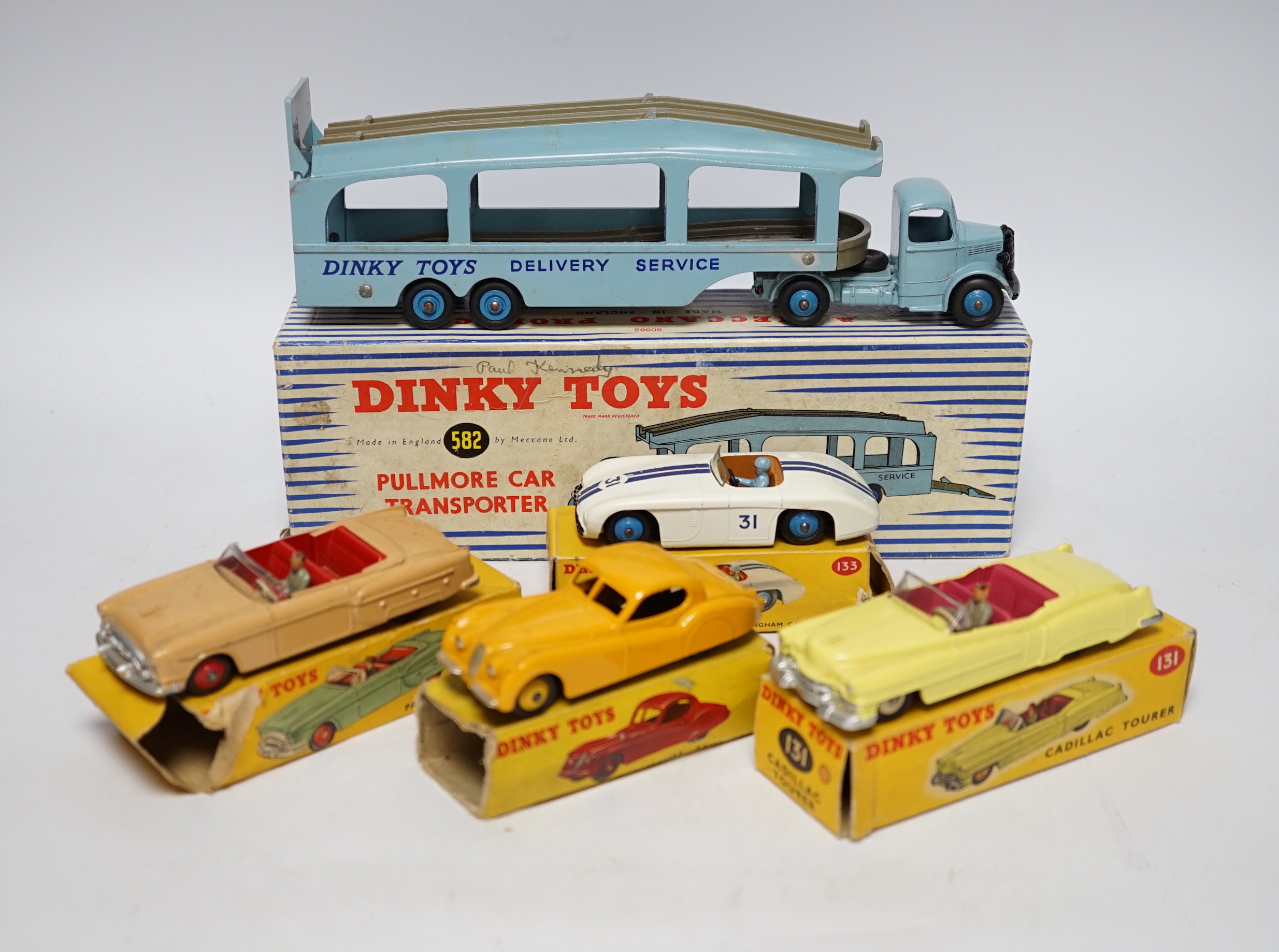 Five boxed Dinky Toys; (132) a Packard Convertible, (131) a Cadillac Tourer, (133) a Cunningham C-5R road racer, (157) a Jaguar XK120 and (582) a Pullmore Car Transporter with a (994) Loading Ramp, together with a Cresce